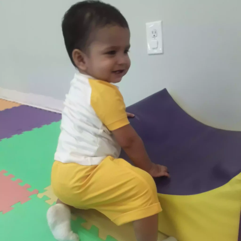 Baby practicing motor skills on soft play mat in infant program