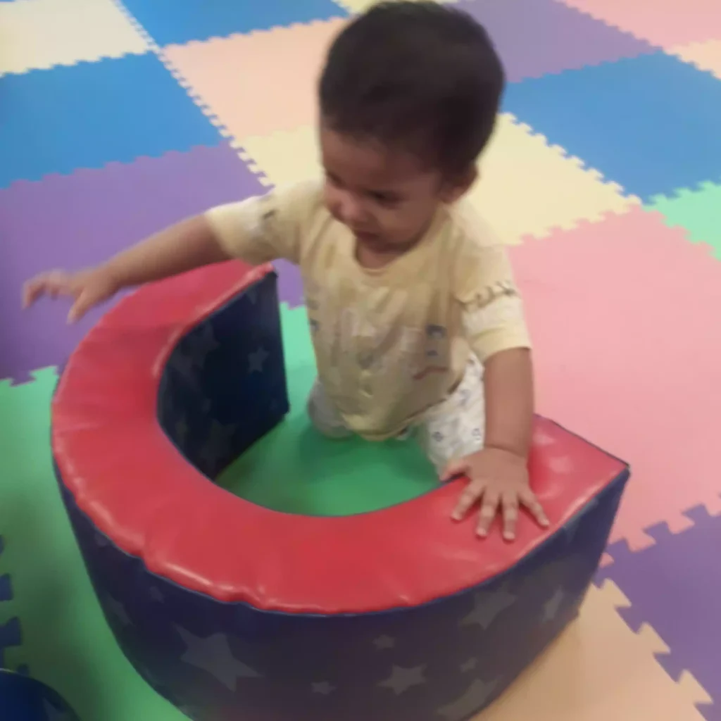 Baby crawling and exploring soft foam climber in infant program