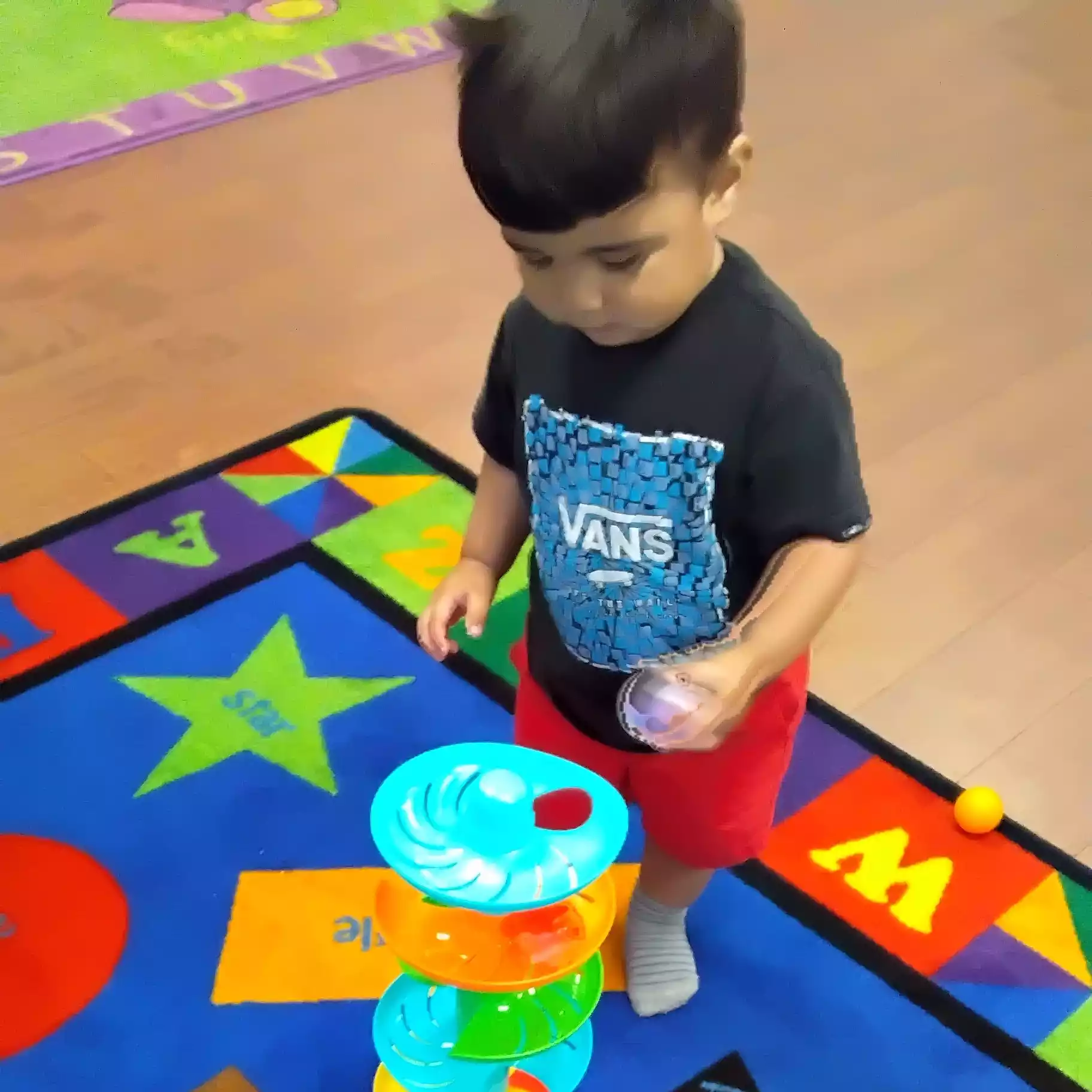 Pinebrook Pre-K Student Playing with Ball Drop Tower Activity - Pinebrook- Preschool - Pinebrook- Preschool Child playing with spiral ball tower at Pinebrook Montessori
