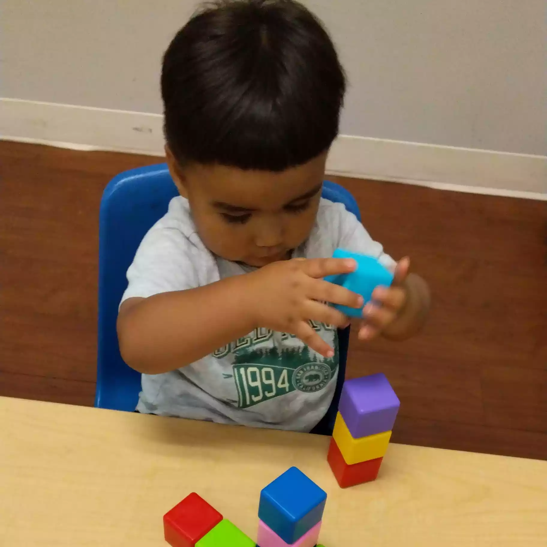 Pinebrook Pre-K Student Stacking Colorful Blocks - Pinebrook- Preschool - Pinebrook- Preschool Pinebrook Montessori student stacking colorful toy blocks