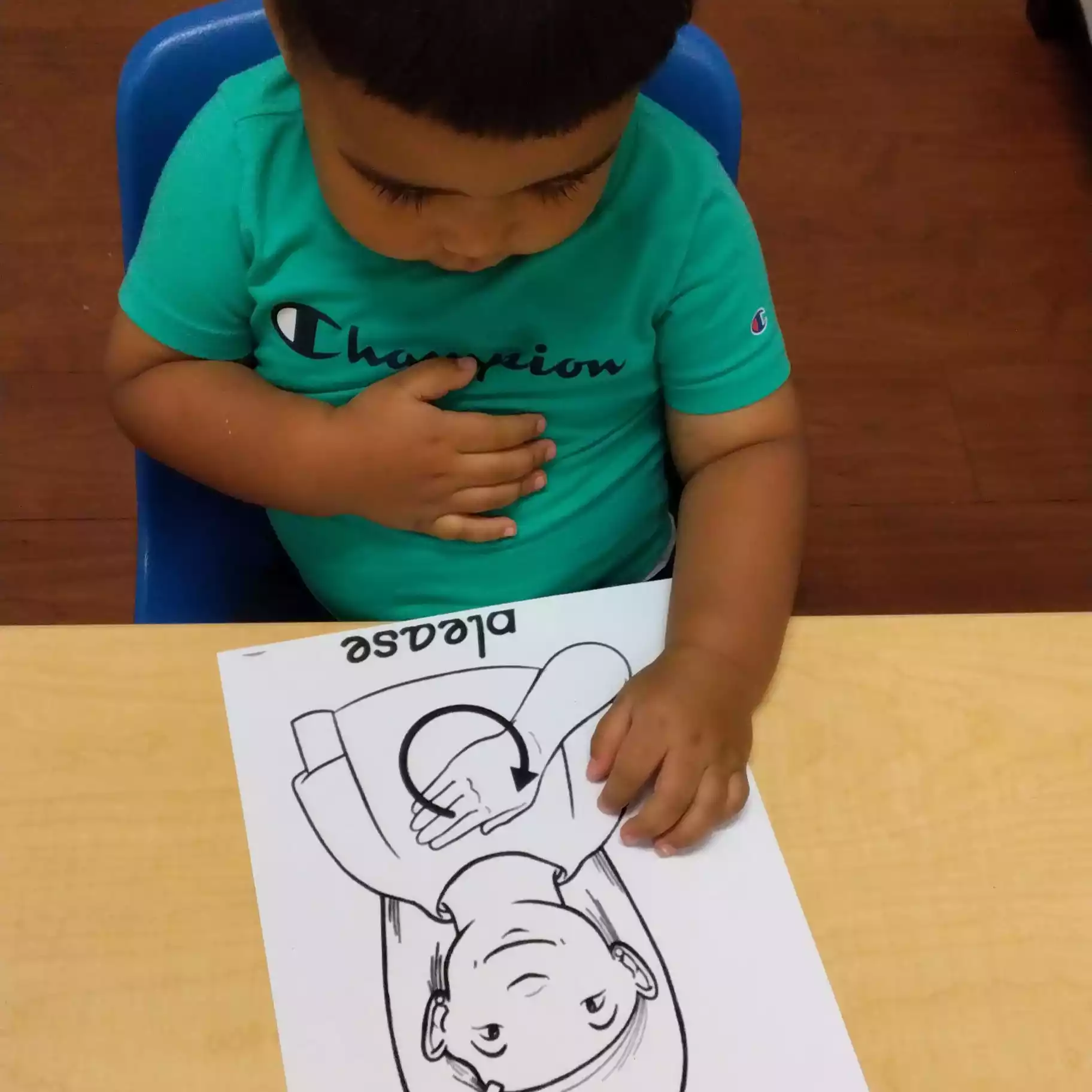 Pinebrook Pre-K Student Practicing Sign Language Activity - Pinebrook- Preschool - Pinebrook- Preschool Student looking at sign language worksheet at Pinebrook Montessori