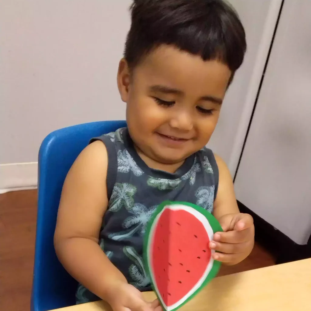 Pinebrook Montessori student holding paper watermelon craft